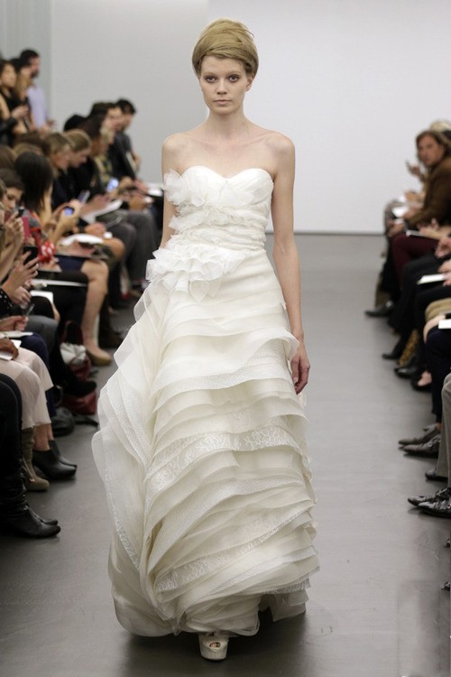 Robe de mariée bustier ivoire avec une jupe étagée fluide signée vera wang.