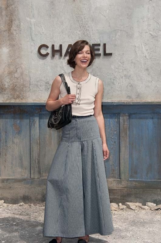  Milla Jovovich est vêtue d'une jupe longue à rayures au défilé Chanel haute couture au Grand Palais