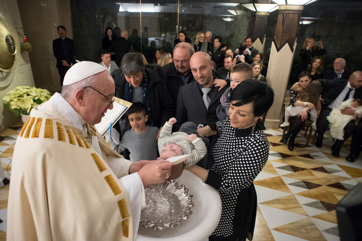 le prêtre fait le baptême pour les enfants